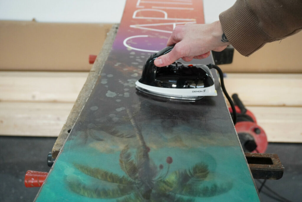 Ironing wax over a snowboard